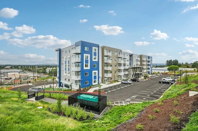 Completed modern multifamily community with parking and landscaped grounds